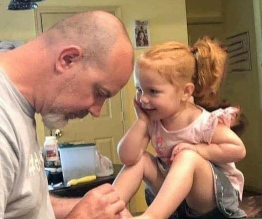 Firefighters at a collision site use nail polish to soothe down a distressed small girl.